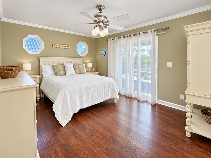 Bedroom with white bedding and wood flooring